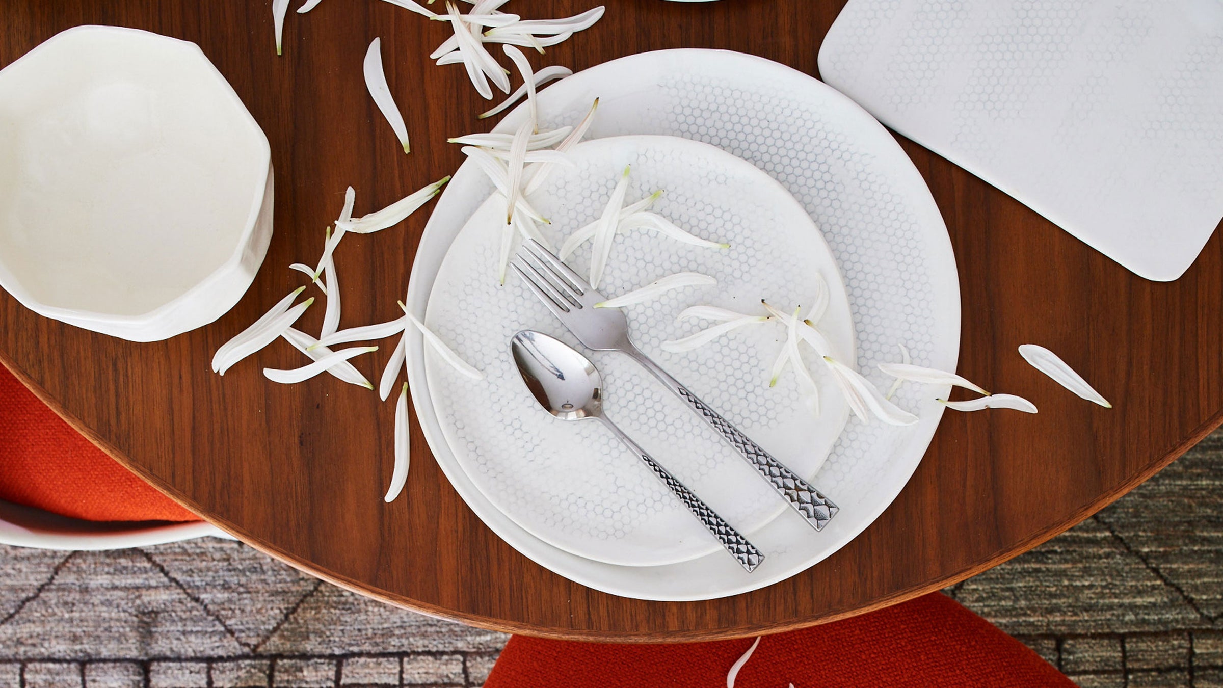 dbo home artisan ceramic honeycomb pattern plate on a wooden table with white leaves and vintage silverware