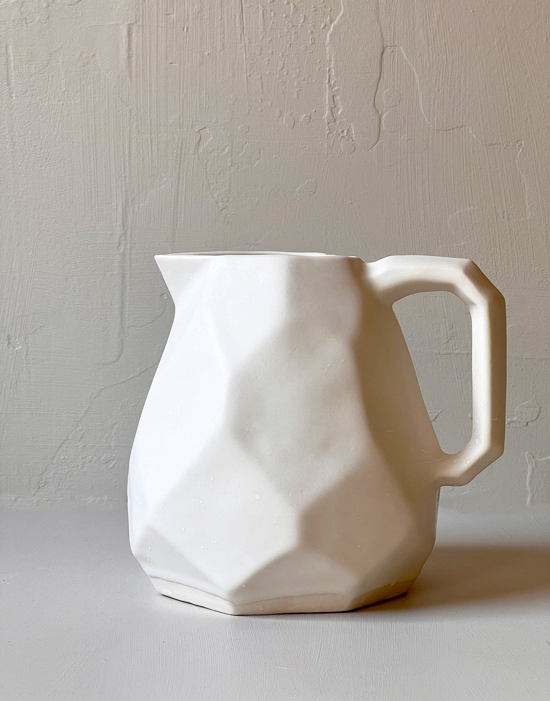Battuto faceted pitcher in snowflake white glaze