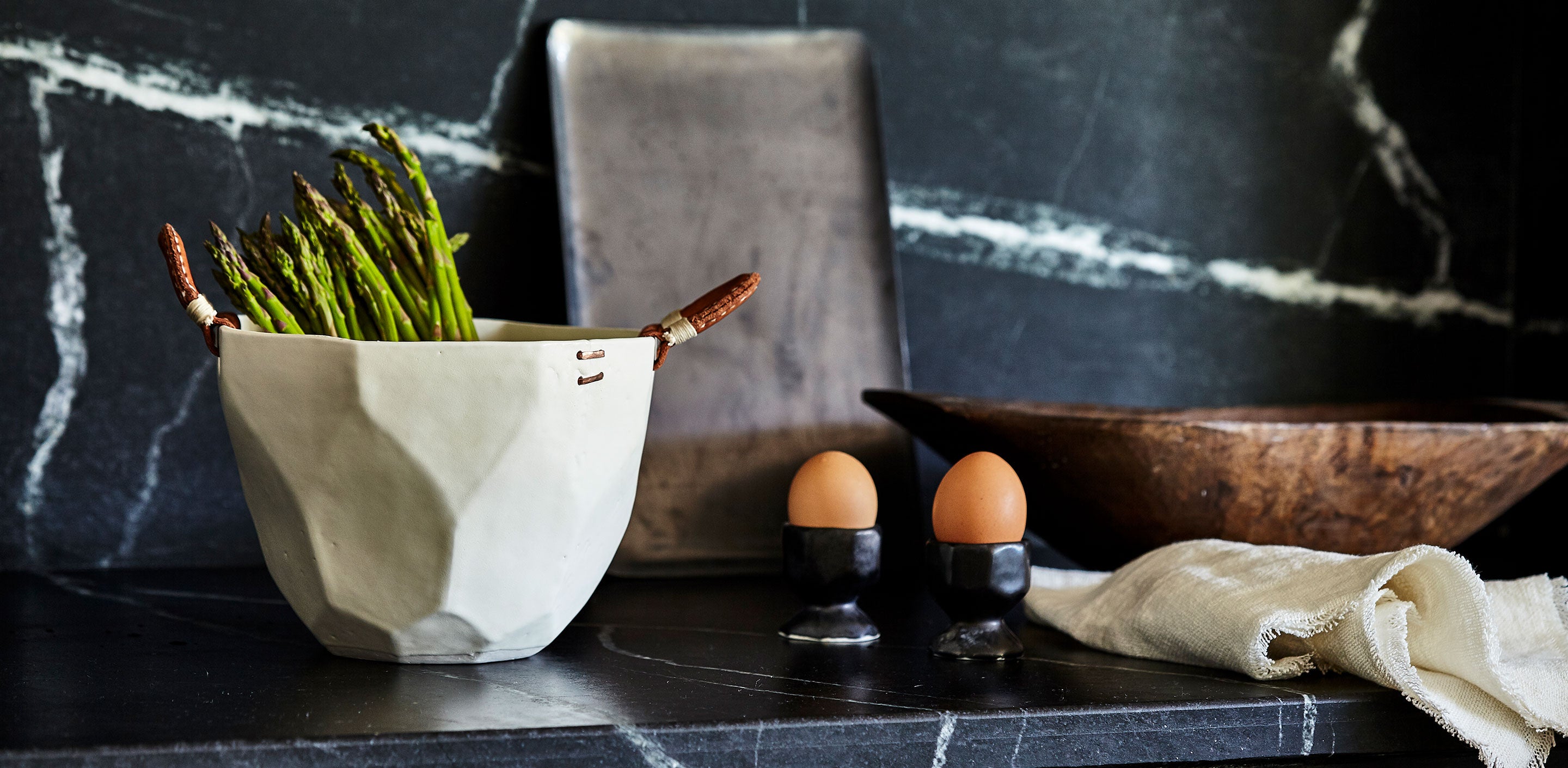 Megan Pflug Catskill Mountain Retreat Tastemakers Table with DBO HOME luxury porcelain MEND battuto ice bucket with leather handles and black ceramic egg cups on black marble countertop
