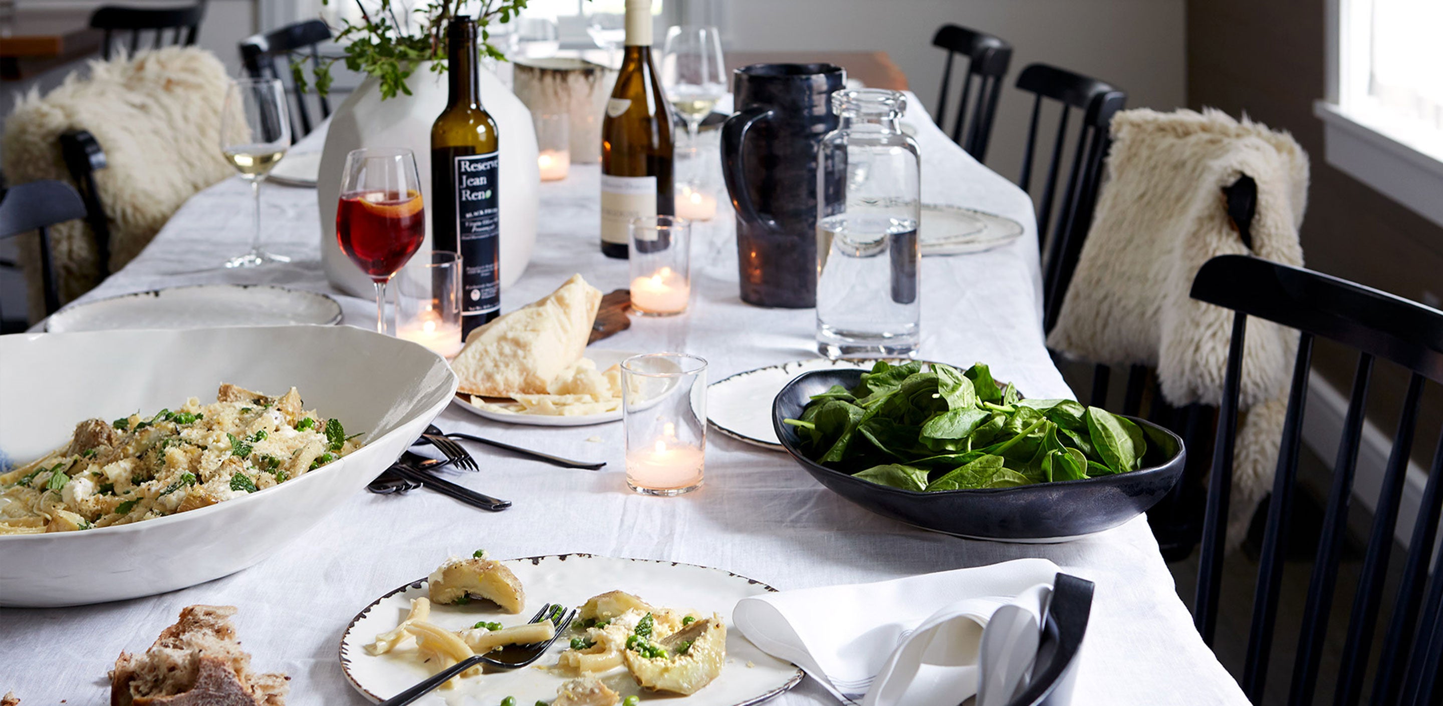 Dane Tashima Community Table Tastemakers Table with DBO HOME black and white porcelain serveware and candles on a cozy table