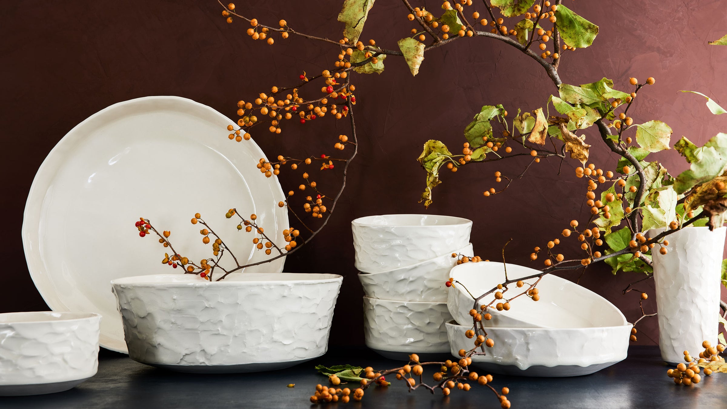 dbo home handmade stucco textured ceramic bowls, platters, and vase with winter berries