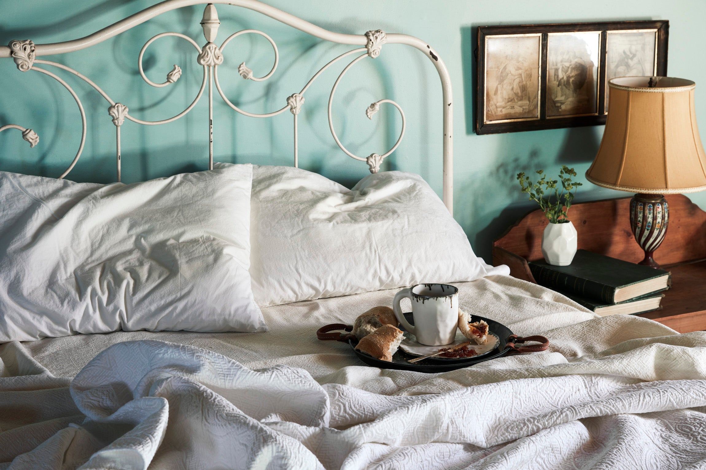 Breakfast in bed.  Cozy vintage bed, with crumpled linens, Remo Tray and Pinch Mug serving coffee and croissants in bed.