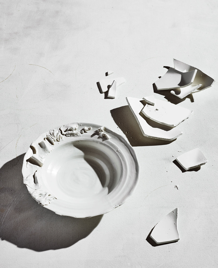Black and white image of one of a kind ruffled bowl and porcelain shards
