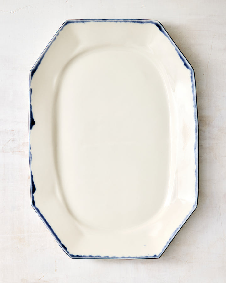 DBO HOME Formale Platter in white porcelain with a softly brushed indigo rim. The octagonal shape and subtle curves bring a timeless structure to this handmade serving piece.