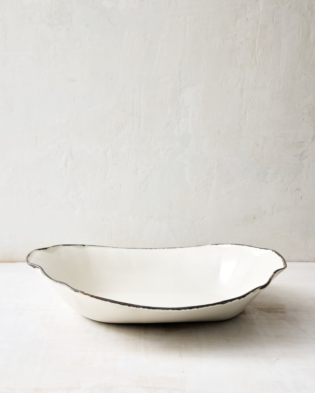 Side profile of the DBO HOME Formale Serving Bowl in white porcelain with a hand-applied bronze rim. Sculptural and versatile, perfect for pastas, salads, or seasonal centerpieces.
