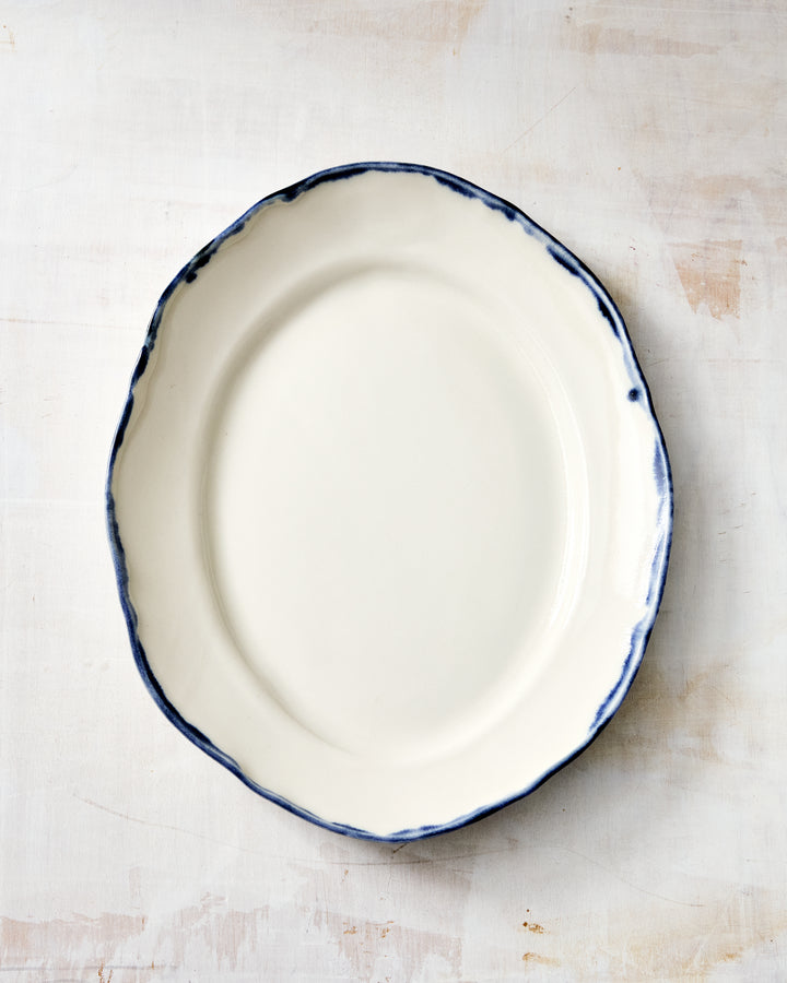 DBO HOME Formale Small Platter in hand-glazed porcelain with a fluid indigo rim. A modern classic with clean lines and subtle depth, ideal for everyday use or casual entertaining.