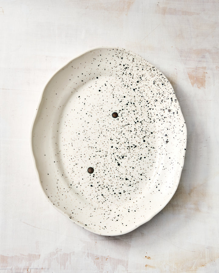 Formale Small Platter by DBO HOME in porcelain with a painterly black speckle glaze. A striking yet unfussy accent piece, with a gently octagonal shape and a refined handmade touch.