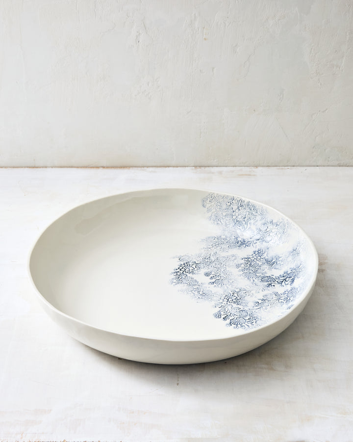Large round porcelain bowl from the Kashmir collection, featuring an indigo floral motif on a handcrafted serving piece.