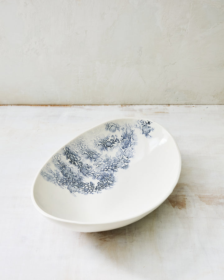 Oval porcelain bowl from the Kashmir collection, featuring a soft indigo floral motif on a handcrafted serving bowl.