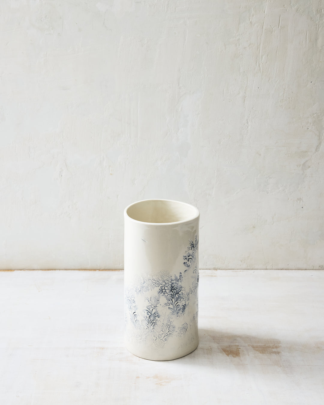 Kashmir small porcelain vase with subtle indigo floral pattern on white glaze, handcrafted ceramic vessel shown from the back