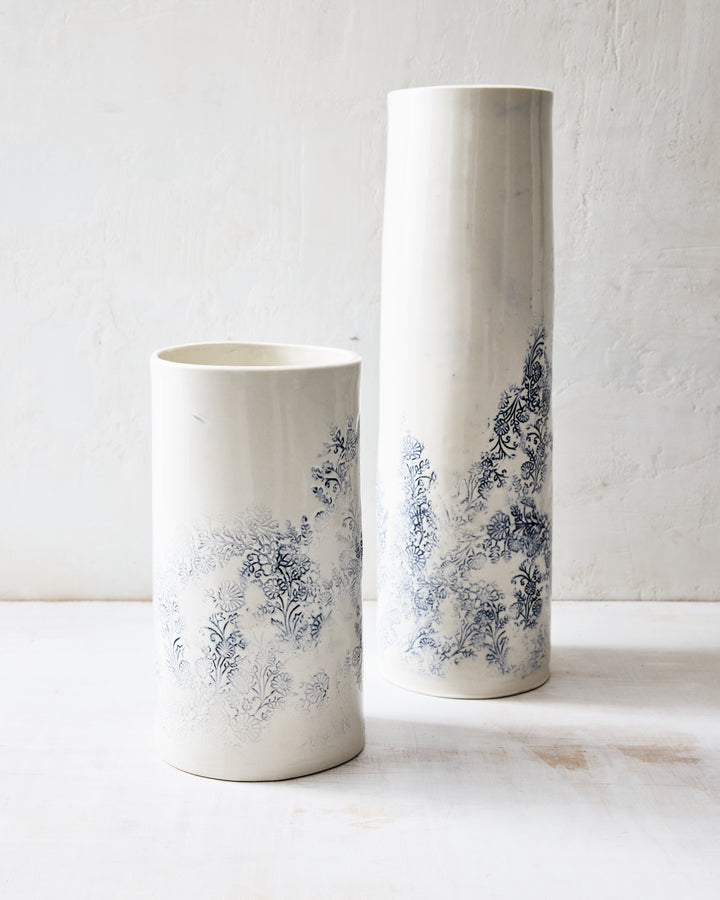Kashmir porcelain vases in small and tall sizes, handmade white ceramic vases with blue indigo floral design displayed together.