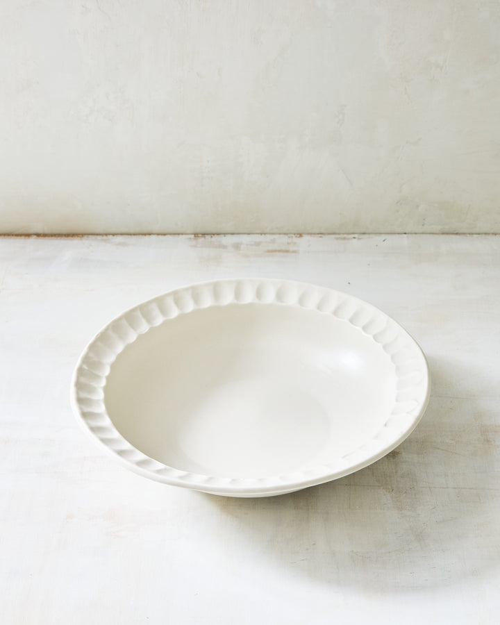 DBO HOME Nonna Pasta Bowl in warm white porcelain with a softly scalloped rim. Coated in Snowflake glaze over porcelain, this handmade ceramic bowl brings understated elegance to everyday dining.