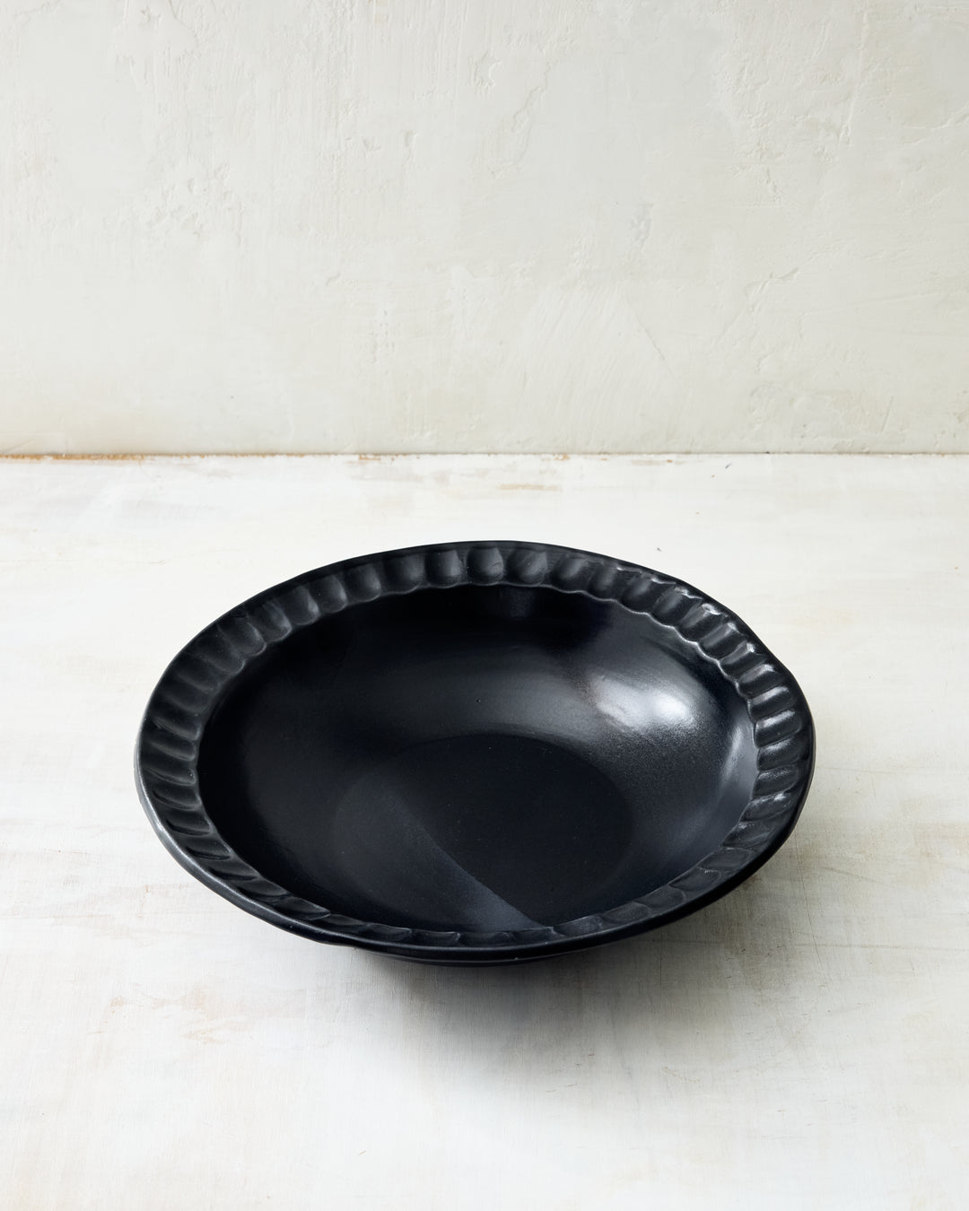 DBO HOME Nonna Pasta Bowl in Matte Black glaze, featuring the collection’s signature fluted rim. The satin-black glaze offers a soft sheen and rich depth, bringing a minimalist, modern touch to this handmade ceramic serving piece.