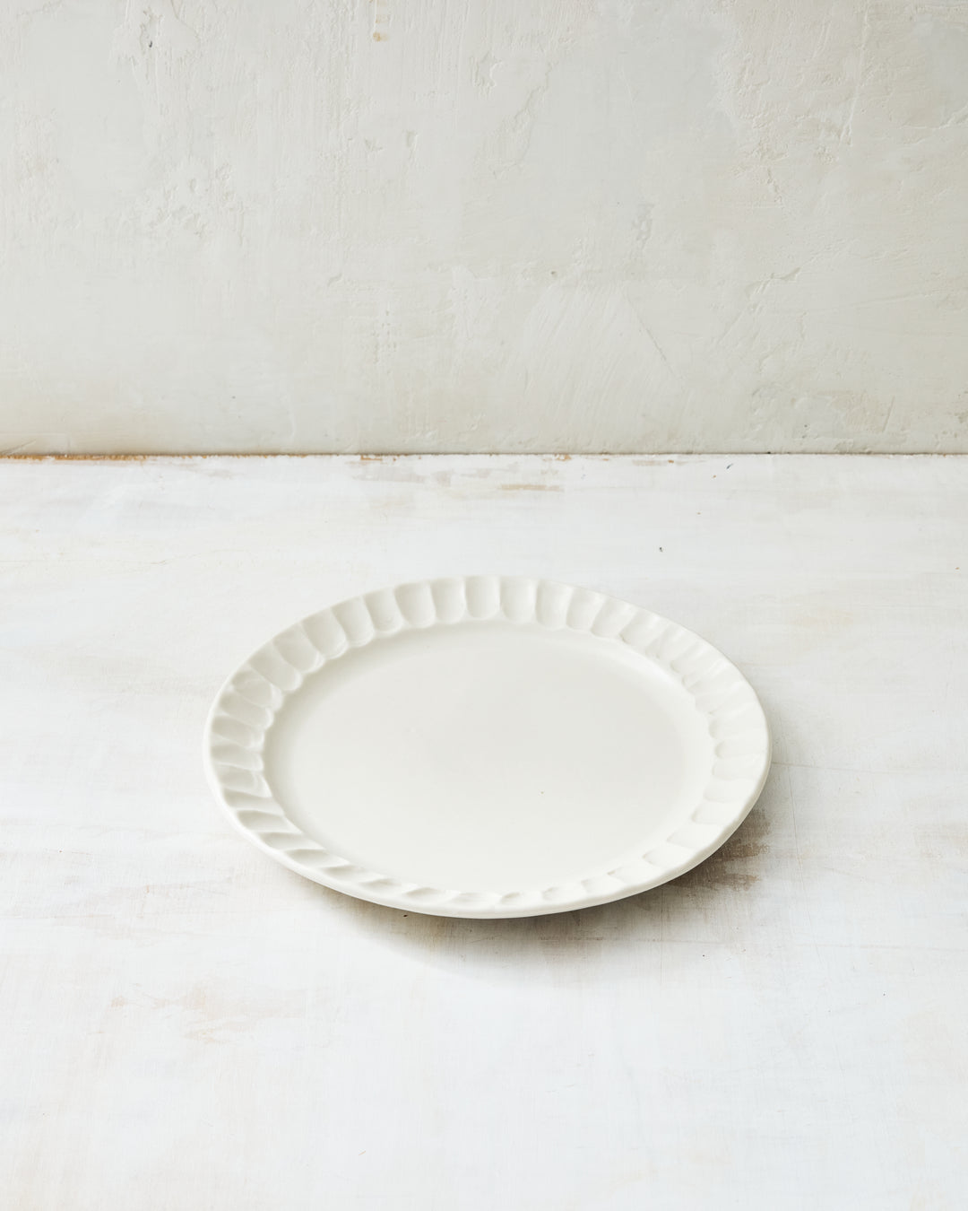 DBO HOME Nonna Salad Plate in white porcelain with a shimmering satin glaze finish and gently fluted rim. This ceramic side plate brings quiet beauty to everyday meals or elegant gatherings.