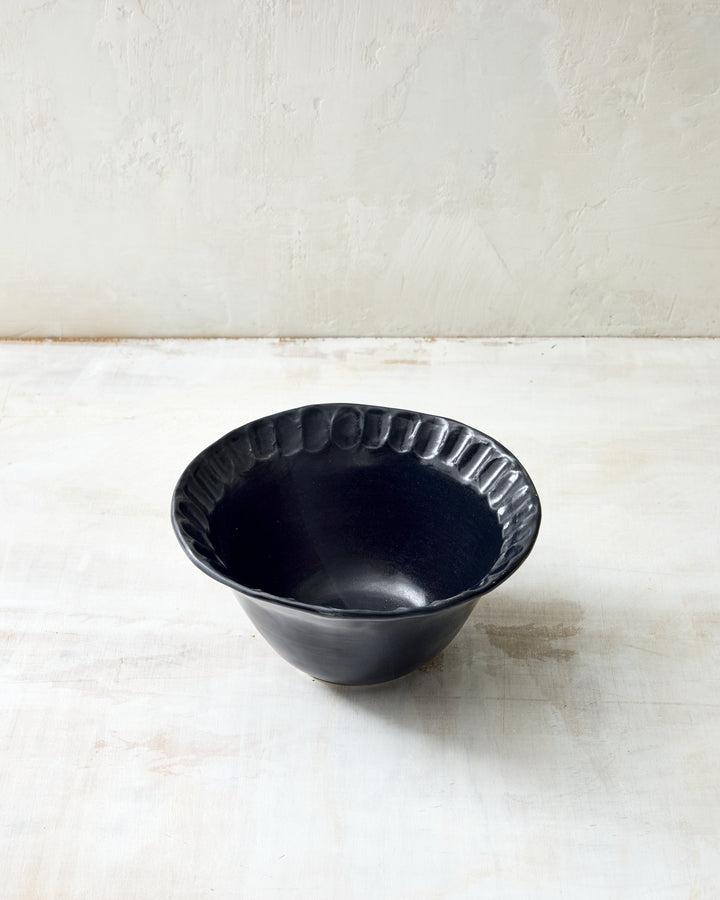 DBO HOME Nonna Small Bowl in Matte Black glaze with a fluted rim and curved profile. This handmade ceramic bowl offers a refined, modern look for snacks, side dishes, or morning granola.