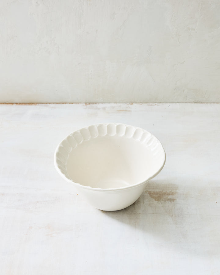 DBO HOME Nonna Small Bowl in creamy porcelain with shimmering Snowflake glaze and soft fluting along the rim. A versatile handmade piece that feels equally at home on a breakfast table or in a formal setting.
