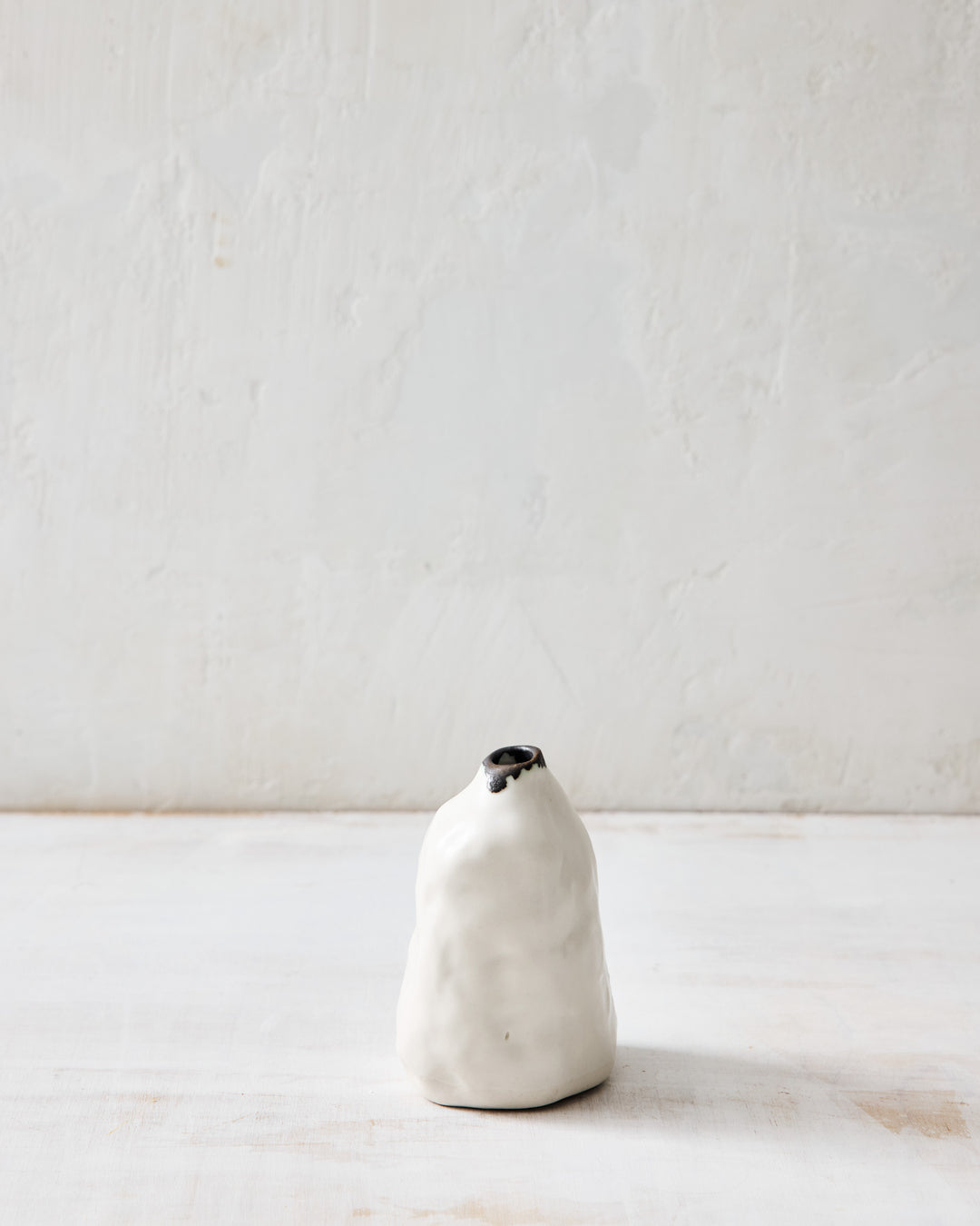 Handcrafted in porcelain, the DBO HOME Paul Pinch Bud Vase features a gently rounded form with a dark bronze rim and organic pinch marks. A minimal bud vase with soulful, earthy character.