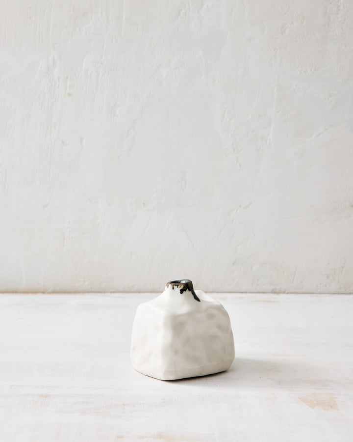 DBO HOME Pinch Bud Vase – Ringo, crafted in creamy porcelain with a dark glazed neck. Its compact, pebble-like form adds quiet texture to any corner, shelf, or bedside.