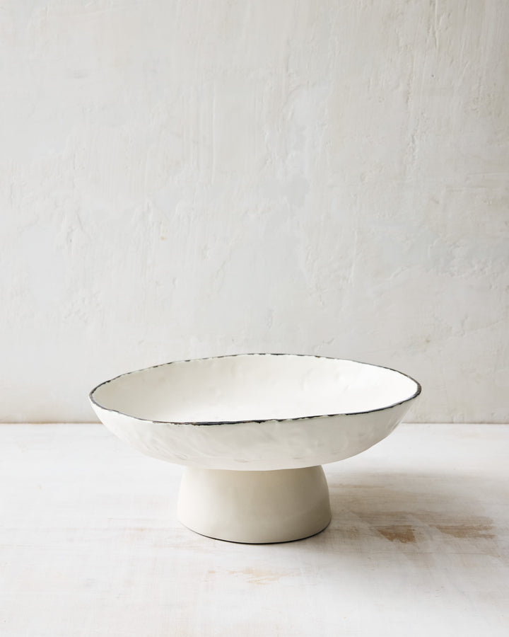 The DBO HOME Pinch Fruit Bowl in hand-formed white porcelain. With a wide, shallow basin and sculptural foot, this ceramic serving bowl blends elegance with everyday ease—perfect for fruit, bread, or display.