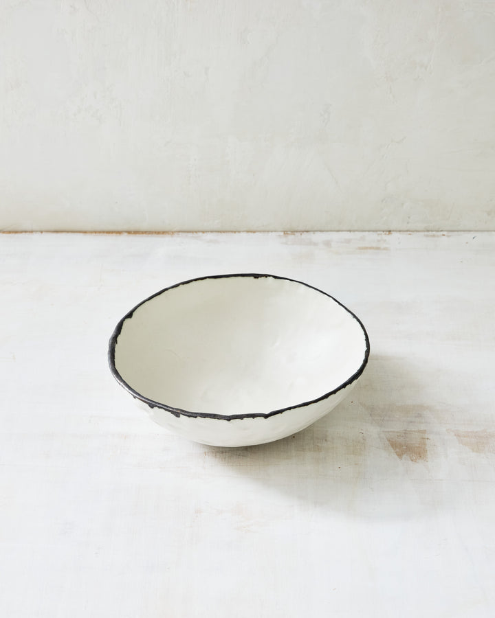 DBO HOME Pinch Noodle Bowl in hand-thrown porcelain with a dark bronze rim. Deeper and slightly flared, this artisanal ceramic bowl is perfect for ramen, pasta, or cozy one-bowl meals. Shown on a minimal white backdrop.