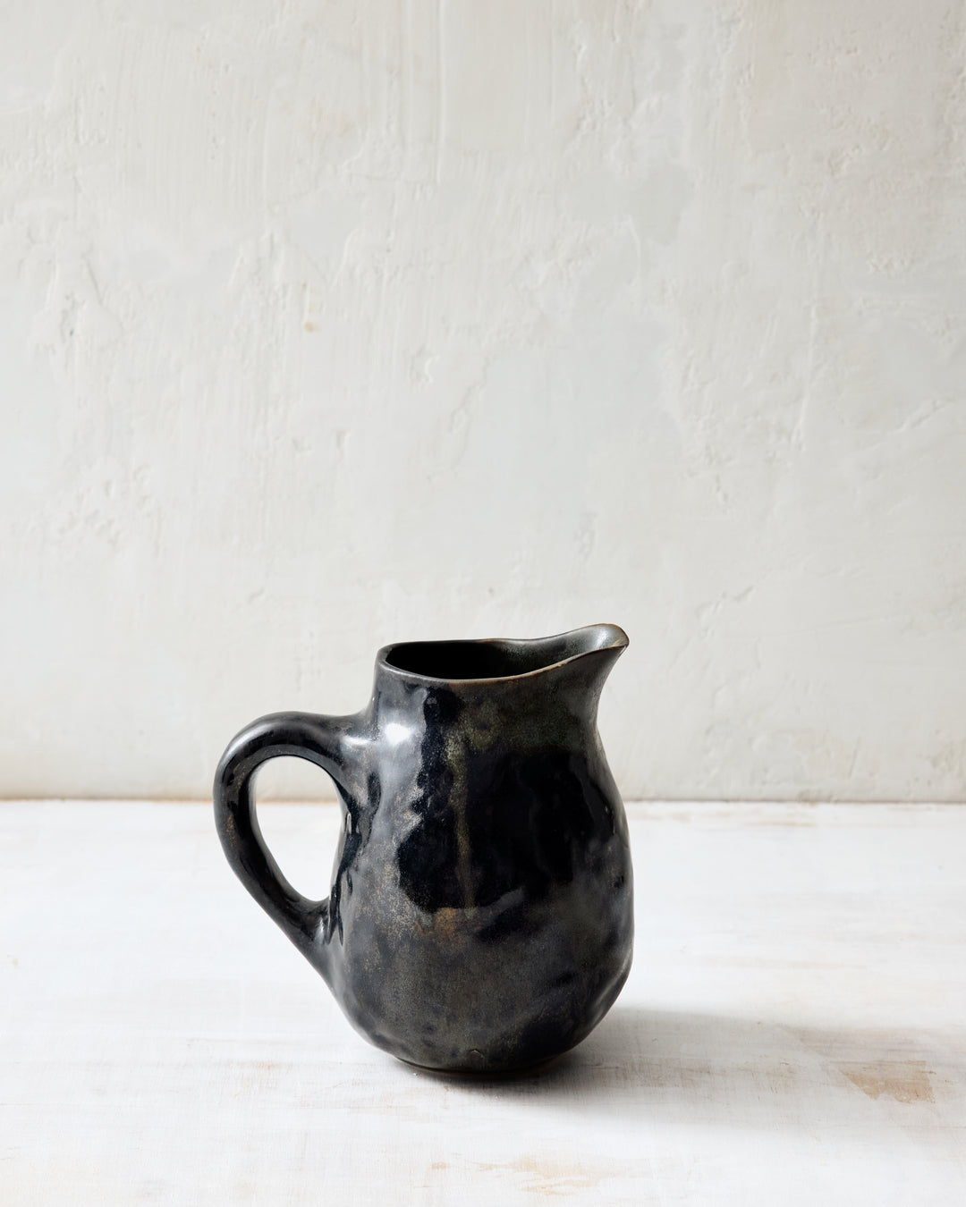 DBO HOME Wabi Pitcher in Granite glaze, handmade porcelain with a layered mussel and snowflake glaze, stone-like surface texture, and a soft handle, side view.