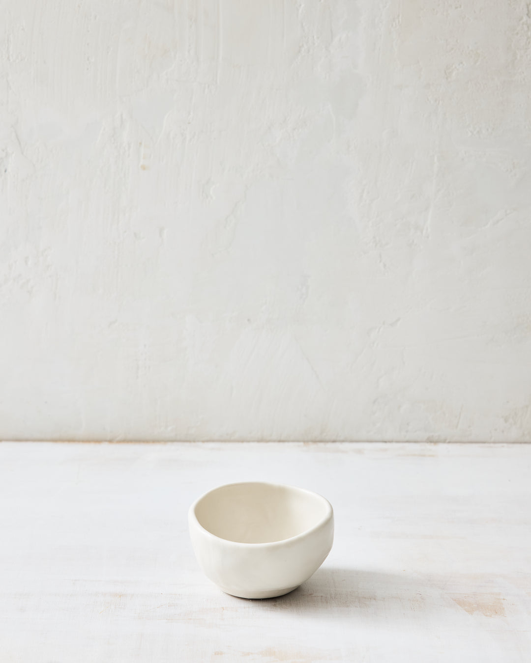 DBO HOME Wabi Salt Cellar in Foam glaze, handmade porcelain with a subtle white-on-white layered glaze and stone-like surface texture, photographed on a whitewashed surface.