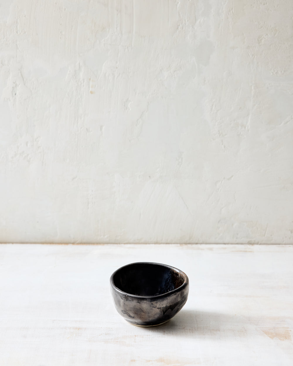 DBO HOME Wabi Salt Cellar in Granite glaze, handmade porcelain with a layered mussel and snowflake glaze and stone-like surface texture, photographed on a whitewashed surface.