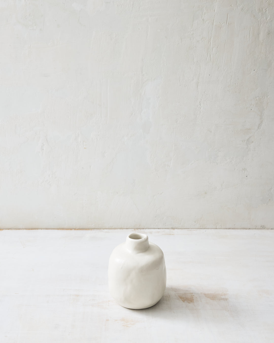 Short Wabi ceramic vase in Foam glaze with a rounded, hand-thrown shape and subtle surface texture, finished in Foam white and styled on a white surface.