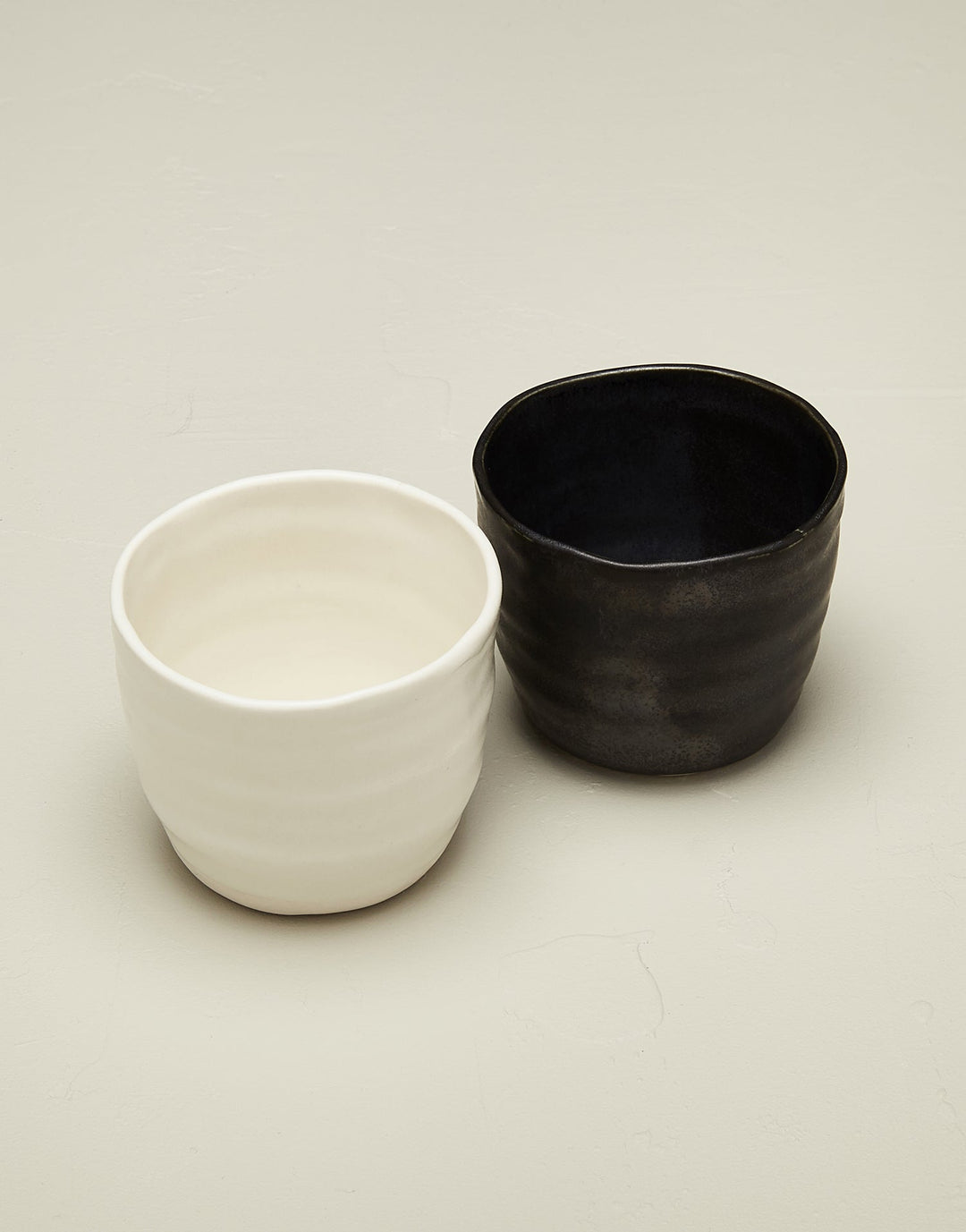 Artisan ceramic black and white bare tumbler cups in snowflake and mussel glaze
