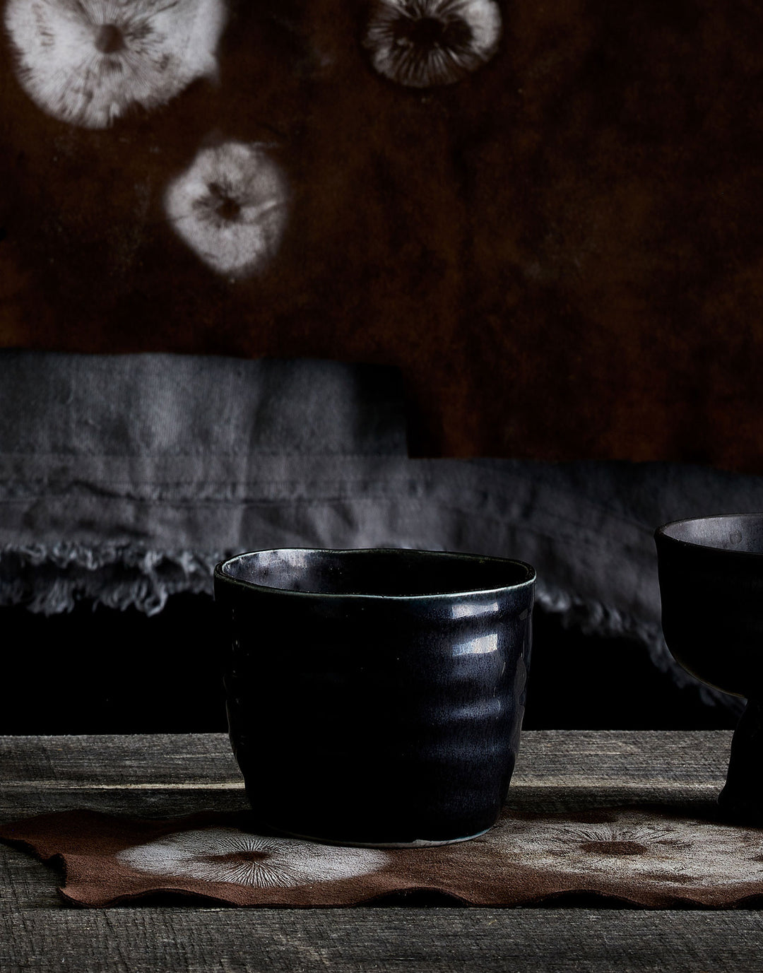 DBO HOME black porcelain tumbler on dramatic natural dark background