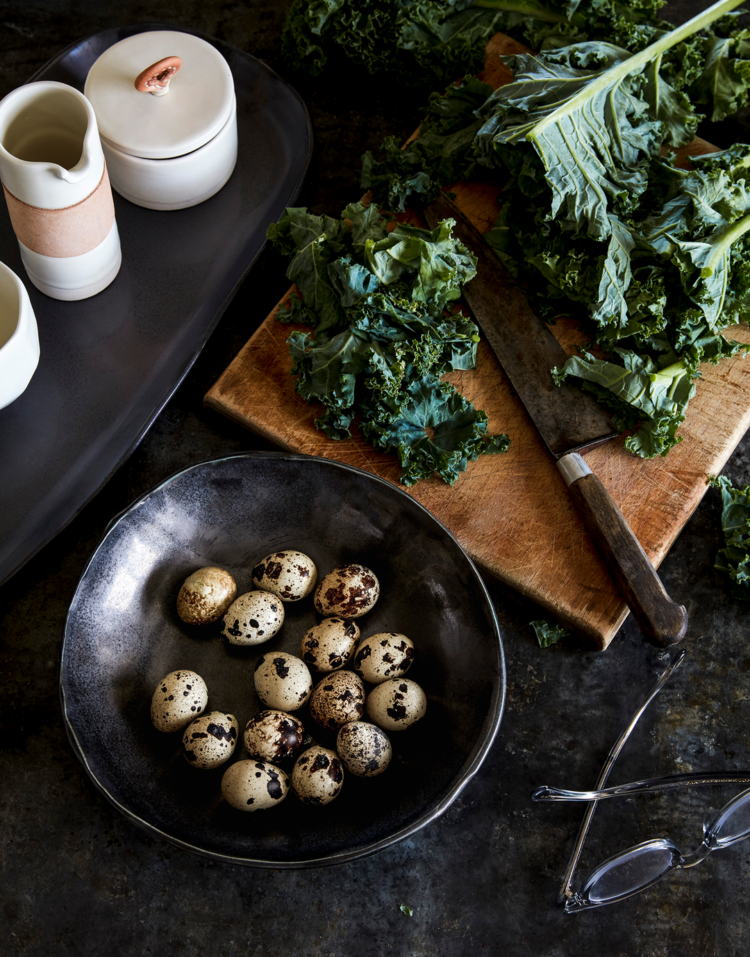 DBO HOME black small batch artisan made porcelain bowl on kitchen counter with kale