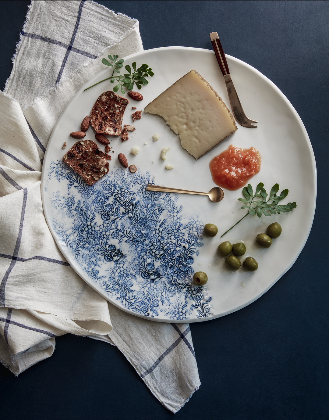 DBO HOME white artisan ceramic xl platter with blue kashmir indian woodblock print design serving cheese and olives with white linen cloth